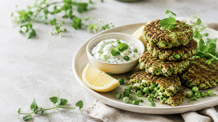 Super greens pea and feta fritters with lemon-herb yoghurt, fresh peas and lemon
